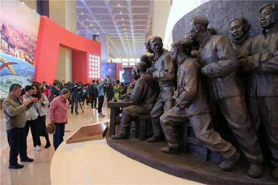 Visitors view a group statue commemorating the 40th anniversary of China's reform and opening-up at the National Museum of China in Beijing on Wednesday. (Wang Zhuangfei/China Daily)