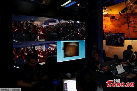 The mission control team at NASA's Jet Propulsion Laboratory (JPL) react on a video screen as the spaceship Insight, NASA's first robotic lander dedicated to studying the deep interior of Mars, sends its first picture back to JPL, in Pasadena, California, U.S. November 26, 2018.(Photo/Agencies)