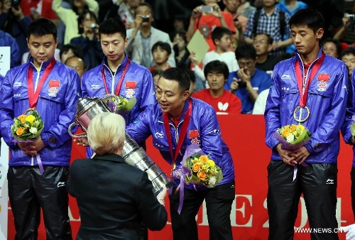 Liu Guoliang (2nd right), then Chinese head coach, receives the trophy during the awarding ceremony for the men's group event in Zen Noh 2014 World Table Tennis Championships in Tokyo, Japan, May 5, 2014. China beat Germany 3-1 in the final and claimed the title of the event. (Photo: Li Peng/Xinhua)