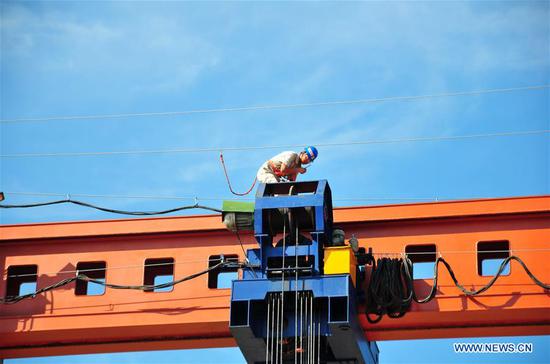 A technician works at the construction site of the first China-Laos Railway T-shaped concrete beam in Lao capital Vientiane, Dec. 2, 2018. The successful erection of the first simply supported T-shaped concrete beam marks that the construction of China-Laos railway has been transferred from substructure to superstructure. (Xinhua/Zhang Jianhua)