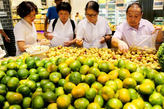 Shoppers select fruits at a supermarket in Lianyungang, Jiangsu province, Sept 10, 2018. [Photo/Xinhua]