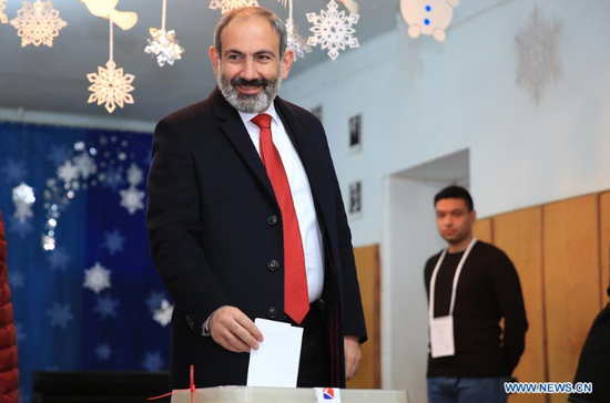 Armenia's acting Prime Minister Nikol Pashinyan (L) casts his ballot at a polling station in Yerevan, Armenia, on Dec 9, 2018.(Photo/Xinhua)