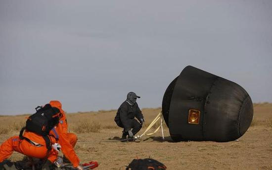 Scientific personnels work at the landing area of the re-entry capsule of China's first retrievable microgravity satellite SJ-10 in Siziwang Banner, North China's Inner Mongolia autonomous region, April 18, 2016. (Photo/Xinhua)