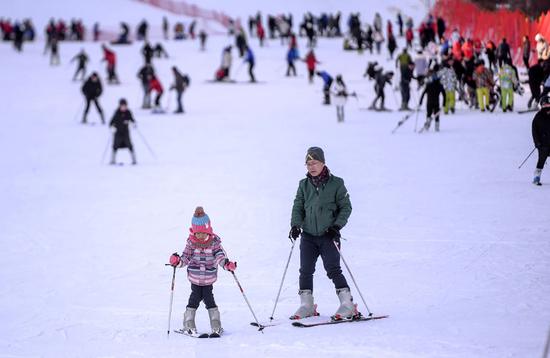 A father coaches his daughter at a ski resort in Beijing's Changping district on Dec 8, 2018. (Photo by PAN ZHIWANG/FOR CHINA DAILY)