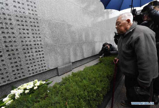 She Wenbin, a family member of a victim of the Nanjing Massacre, mourns in front of the 