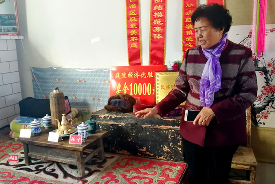 Li Hongxiu, the owner of a folk museum dedicated to the history of the Huerjia, displays a kang, or brick bed, used by Cao Guangyou, a third-generation Huerjia. (Photo: China Daily/Zhang Yi)