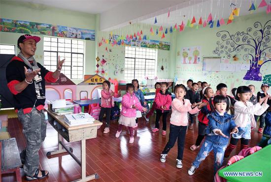 Kindergarten children take music lesson in Banmu Village of Wa Autonomous County of Ximeng, southwest China's Yunnan Province, Dec. 7, 2018.  (Xinhua/Yang Zongyou)