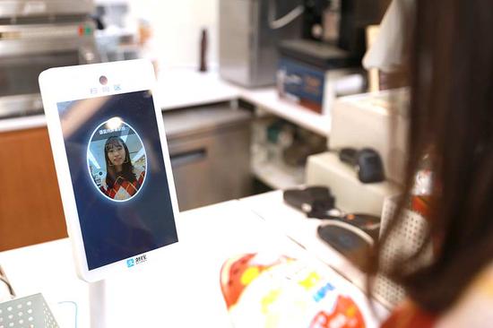 An Alipay employee tests the Dragonfly, formerly known as 'Smile to Pay', at a convenience store in Hangzhou, capital of Zhejiang province. [Photo provided to China Daily] 