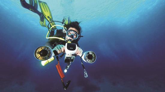 A diver uses an underwater booster developed by underwater robot producer Sublue. (Photo provided to China Daily)
