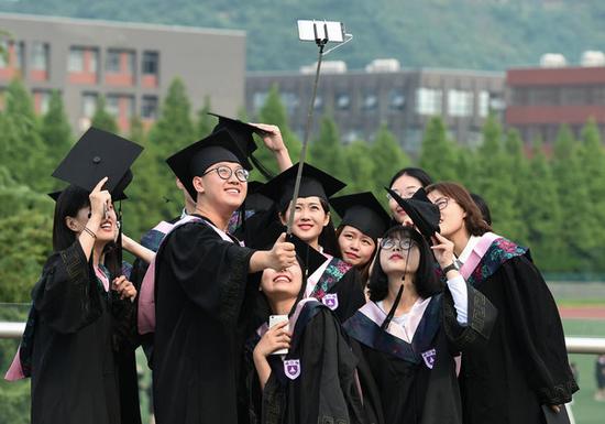 Nanjing University students take group photos after their graduation ceremony. [Photo/Xinhua]