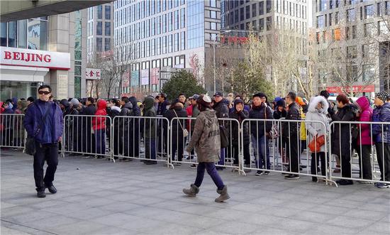 People line up outside the headquarters of Ofo to ask for refunds of their deposits in Beijing on Tuesday. (Liu Hongsheng/For China Daily)