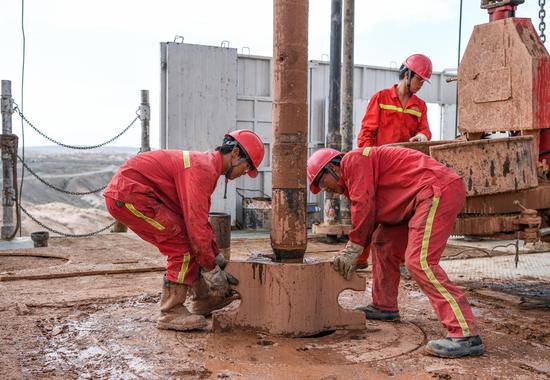 Employees of a petroleum exploration company work at a newly established drilling platform in Aksu, the Xinjiang Uygur autonomous region. (Photo/Xinhua)