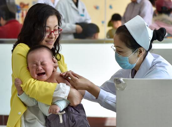 A mother gets her child vaccinated at a community health center in Tianjin's Hongqiao district in April. (Photo/Xinhua)