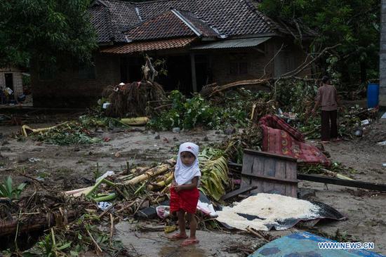 A child stands in tsunami debris at Tanjung Lesung district of Pandeglang, Banten Province, Indonesia, Dec. 25, 2018. Casualty from the tsunami triggered by a volcanic eruption in Sunda Strait in Indonesia climbed to 429 people on Tuesday, spokesman of national disaster management agency Sutopo Purwo Nugroho told a press conference. (Xinhua/Veri Sanovri)