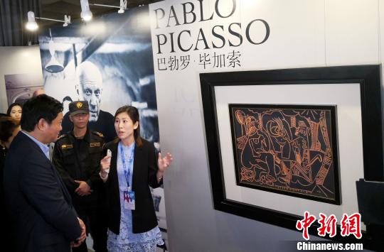 Visitors at an art exhibition in Haikou stop in front of Picasso's master piece  