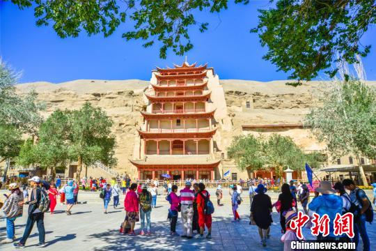 Tourists visit Mogao Grottoes in Dunhuang City, Northwest China's Gansu Province, in July 2018.  (Photo/China News Service)