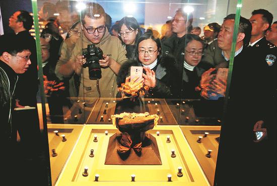 A Qing Dynasty (1644-1911) royal crown attracts attention on Wednesday at a Beijing exhibition on the theme of relics recovered after theft. (Photo/China Daily)