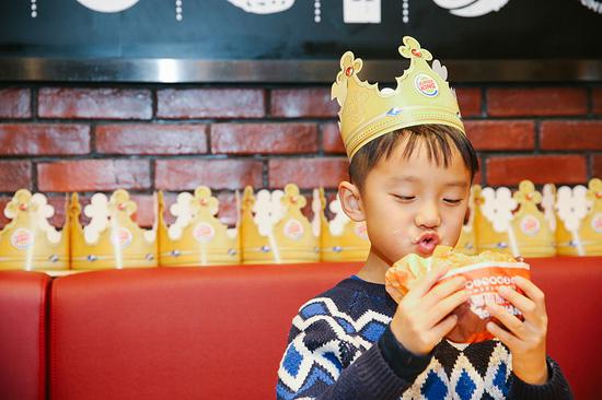 A boy has a bite at a Burger King restaurant in Shanghai. (Provided to China Daily)