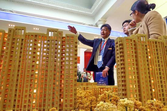 A salesman introduces properties at an industry expo in Shanghai. (Photo by Shen Jingwei / for China Daily)