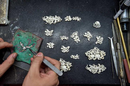 A goldsmith prepares molds for gold accessories at Batar Group in Shenzhen, Guangdong province. (Photo/Xinhua)