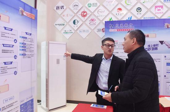 A bank employee introduces loan policies to an entrepreneur at a matchmaking event for banks to provide finance to smaller companies in Tongling, Anhui province. (Photo/for China Daily by Guo Shining)