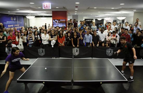 Photo taken on Sept. 16, 2017 shows Chinese table tennis player Wang Hao (front R) playing with ping-pong fans at a club in Chicago, the United States. (Xinhua/Wang Ping)