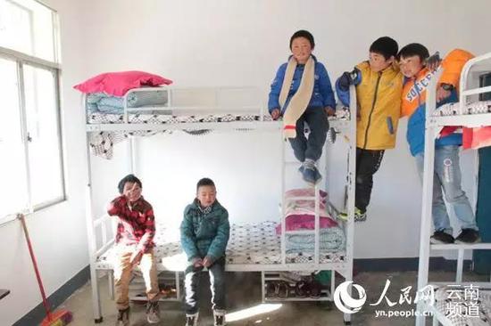 Wang (C) stays with his classmates at the school's dormitory. (Photo via yn.people.cn)