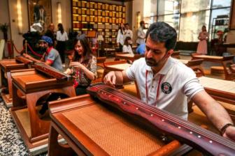 Foreigners learn to play the guzheng, a Chinese plucked string instrument, in October at a medical tourism center in Qionghai, Hainan Province, where visitors can get a taste of Chinese culture and medicine. (Photo by Yuan Chen/For China Daily)