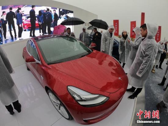 Visitors look at a Tesla Model 3 car in Shanghai, Jan. 7, 2019. (Photo/China News Service)