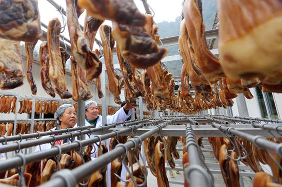 With rapid urbanization, the curing of the festive meats is now done in factories. (Photo by CHEN DONGDONG/FOR CHINA DAILY)