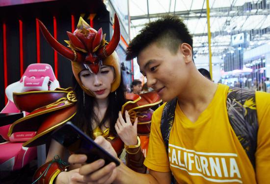 Fans look at game products on show at an industry expo in Shanghai. (Photo by Long Wei/For China Daily)