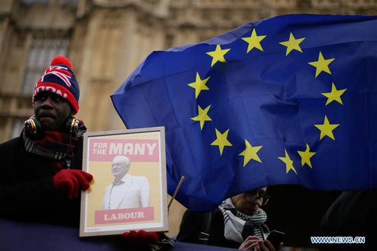 A demonstrator supporting British Labor party leader Jeremy Corbyn stands outside the Houses of Parliament in London, Britain, on Jan. 16, 2019. The British parliament on Tuesday rejected overwhelmingly the Brexit deal. Main opposition Labor party leader Jeremy Corbyn tabled a motion of no confidence, with a debate scheduled for Wednesday to decide whether May's government will collapse. (Xinhua/Tim Ireland)