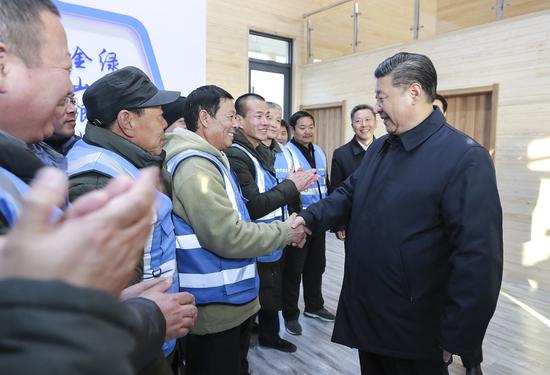 President Xi Jinping greets forest rangers at a woodlands zone in Xiongan New Area, Hebei province, on Wednesday. Xi emphasized the role of nurturing the natural environment to boost the area's value and livability. (Photo/Xinhua)