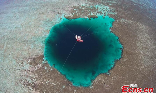 A view of the newly named Sansha Yongle Blue Hole in Xisha Islands in Sansha City, South China's Hainan Province, July 24, 2016. The almost vertical blue hole, located at 16°31'30?north latitude and 111°46'05?east longitude, measures 130 meters in diameter at the top entrance and 36 meters at the bottom, and is not connected with the ocean. It's said to be the deepest blue hole in the world. (Photo/China News Service)