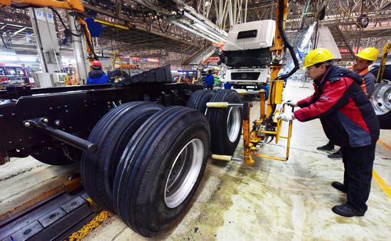 Employees of Shaanxi Automobile and Equipment Co Ltd work at the company's truck assembly line in Xi'an, capital of Northwest China's Shaanxi province, on Jan 3. (Photo by YUAN JINGZHI/FOR CHINA DAILY)