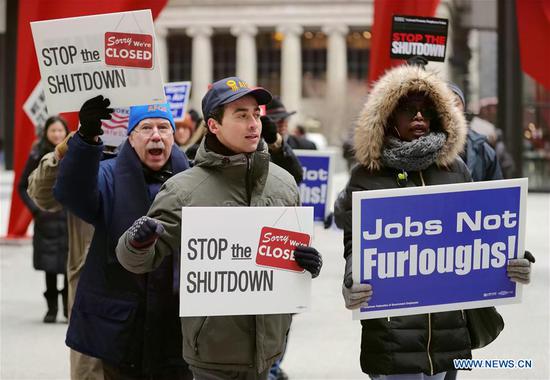 People hold placards during a rally to protest against the partial government shutdown at Federal Plaza in Chicago, the United States, on Jan. 18, 2019. Dozens of federal employees and activists gathered here on Friday to protest against the ongoing partial government shutdown, which is now the longest in U.S. history. (Xinhua/Wang Ping)