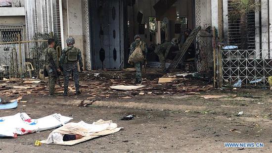 Military personnel look at debris from the explosion scene inside a church on the island of Jolo in Sulu Province, the Philippines, Jan. 27, 2019. Twenty people, including five army soldiers, were killed and 111 others wounded on Sunday as two blasts went off inside and near the entrance of a Roman Catholic church on the island of Jolo in the southern Philippine province of Sulu, police said. (Xinhua/Stringer)