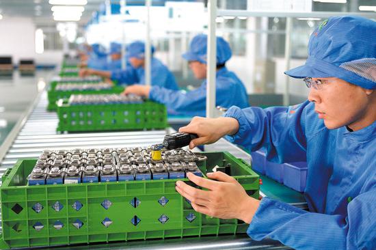 Workers assemble lithium-ion batteries at a production line in Liaoning province.（Photo by Bai Tiejun/For China Daily）