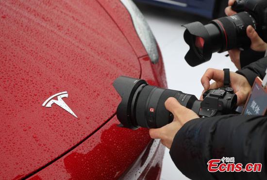 Visitors look at a Tesla Model 3 car in Shanghai, Jan. 7, 2019. (Photo/China News Service)