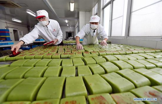 Workers in Jiangsu's Wuxi busy making rice cakes as Spring Festival approaches