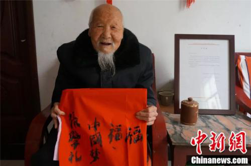 Zhang Xueli, a 117-year-old in Jiaxian county, Henan province, shows the Chinese calligraphy he has written. (Photo/Chinanews.com)