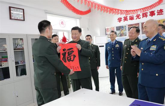 A soldier from a support unit of the People's Liberation Army (PLA) Beijing Garrison Command presents a "good fortune" poster to extend Spring Festival greetings to Chinese President Xi Jinping, also general secretary of the Communist Party of China Central Committee and chairman of the Central Military Commission, in Beijing, capital of China, Feb. 2, 2019. (Xinhua/Li Gang)