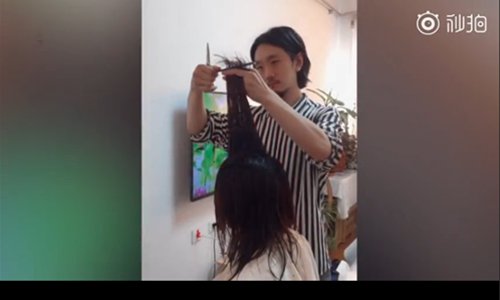 A hairdresser is cutting hair for his families even during his Spring Festival holiday in Harbin, Northeast China's Heilongjiang Province. (Screenshot photo)