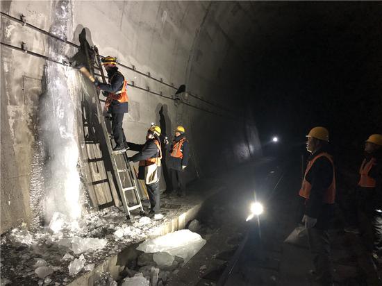 Members of the maintenance squad clear ice on the wall of a tunnel along the Lyuliang section of the Taiyuan-Zhongwei-Yinchuan railway in Shanxi province. (SUN RUISHENG/CHINA DAILY)