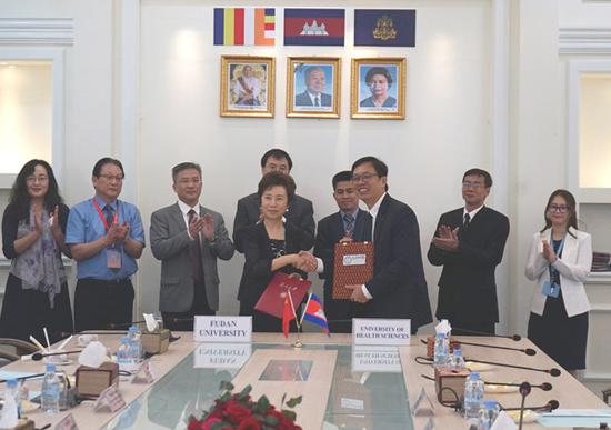 Jiao Yang (fourth from left), Fudan University's chancellor, and Saphonn Vonthanak, rector of Cambodia's University of Health Sciences, shake hands after signing an agreement in January. (Photo provided to China Daily)