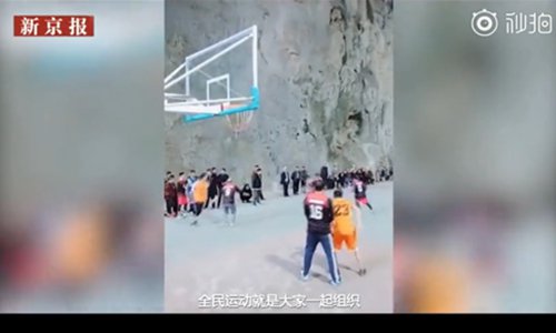 People are playing basketball in a natural cave in Xinchun village, Guizhou Province. (Screenshot photo/The Beijing News)