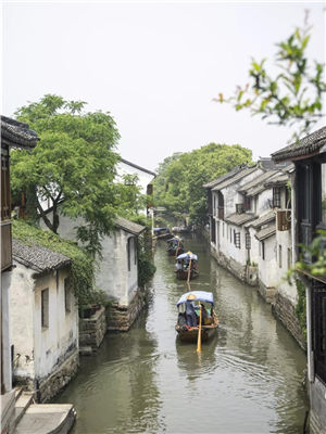 Tourists board a traditional Chinese boat to tour Zhouzhuang in early spring. (Photo provided to chinadaily.com.cn)