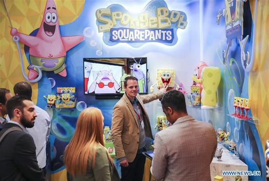 Visitors look at toy products of SpongeBob at the booth of Alpha Group Co., Ltd., a major animation, toy and entertainment player from Guangdong Province in southern China, during the 116th Annual North American International Toy Fair at the Jacob K. Javits Convention Center in New York, the United States, on Feb. 19, 2019. (Xinhua/Wang Ying)