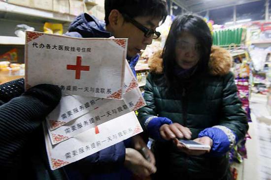 File photo: Contact cards promising to schedule a doctor's appointment for patients are seized by police from a woman near Beijing Children's Hospital. (Cao Boyuan / For China Daily)