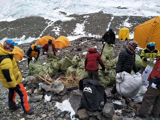 Members of the environmental squad collect trash at base camp on the north face of Qomolangma. (File photo)